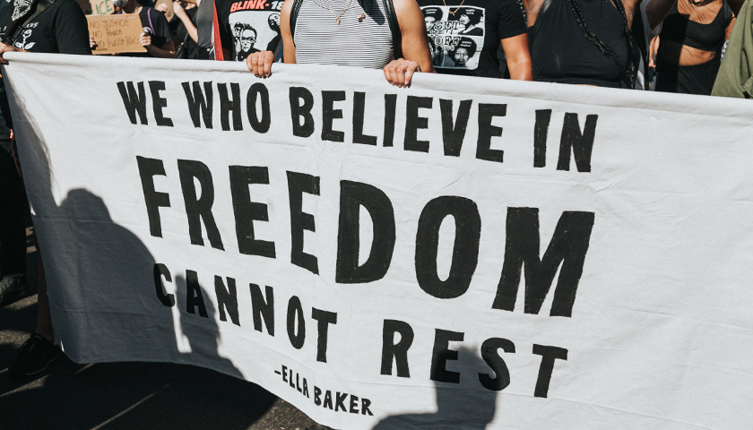 "We who believe in freedom cannot rest," sign