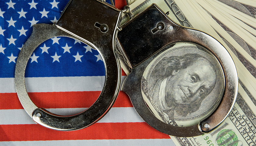 American flag with handcuffs and $100 bills