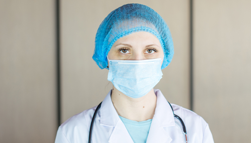 Woman in blue hair net and mask