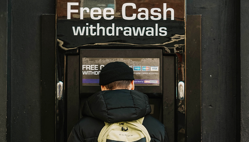 Man standing at an ATM