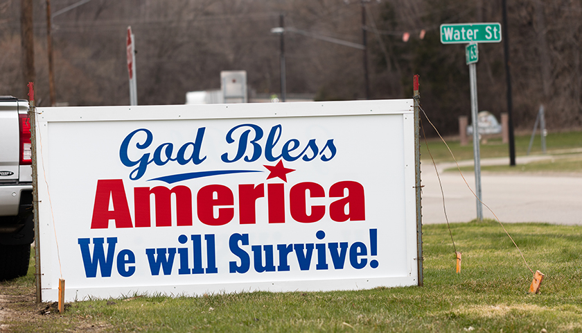 Large sign that reads "God Bless America, We will Survive!"