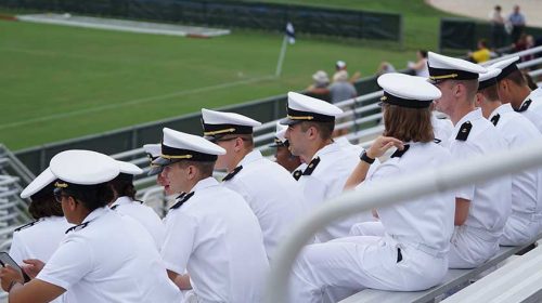group of Navy members sitting on bleachers