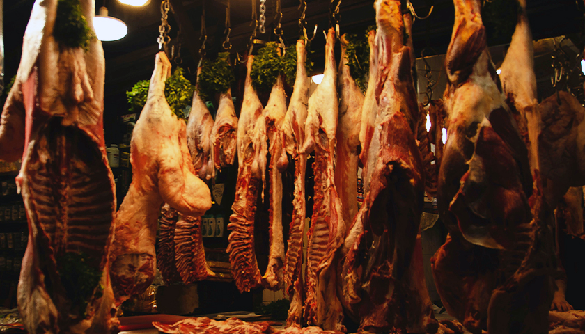 Inside of a butcher shop with meat hanging up